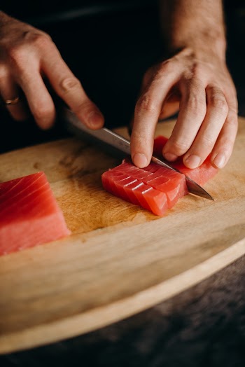 Person Holding Brown Wooden Chopping Board