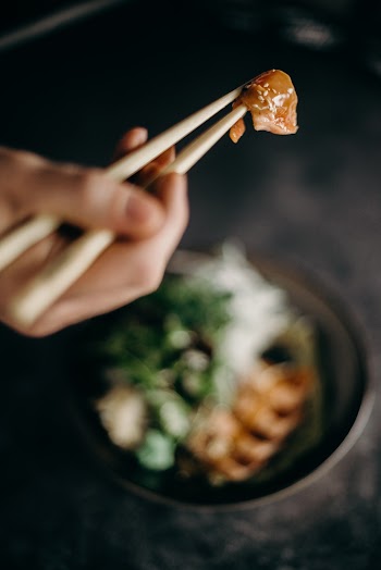 Person Holding Brown Wooden Chopsticks