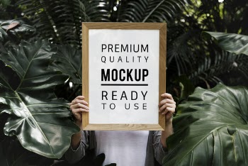 Person Holding Brown Wooden Quote Board in Middle of Green Leafed Plants