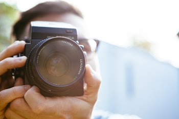 Person Holding Camera during Dayime