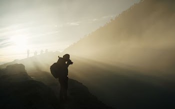 person holding camera during sunset