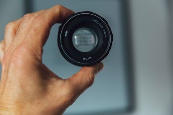 person holding camera lens