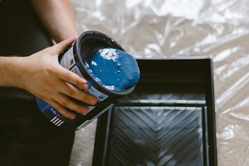 Person Holding Can of Blue Paint