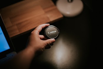 Person Holding Canon Camera Lens Cover