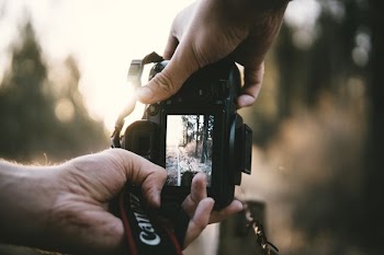 person holding Canon DSLR camera
