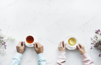 Person Holding Ceramic Teacups
