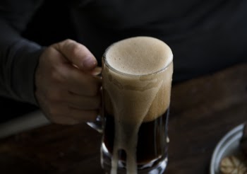 Person Holding Clear Beer Mug Filled With Beer