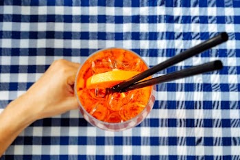 Person Holding Clear Drinking Glass With Two Black Straws