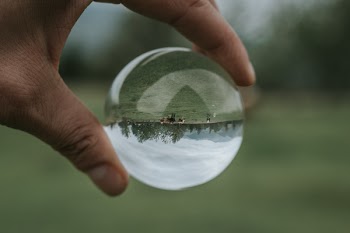 Person Holding Clear Glass Ball Outdoor