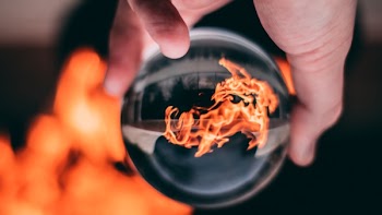 Person Holding Clear Glass Ball With Flame