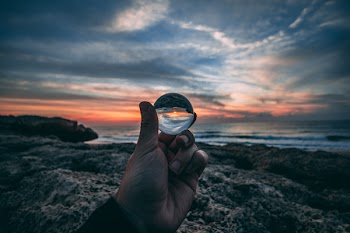 Person Holding Clear Glass Sphere