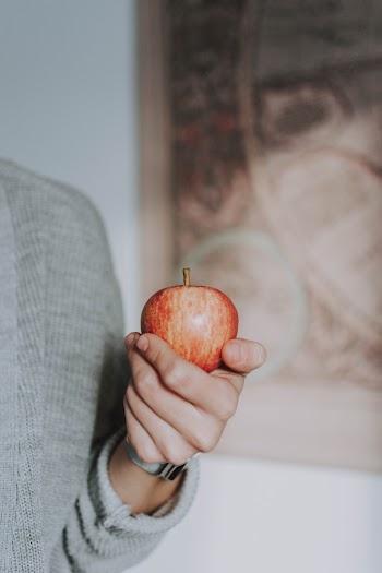 Person Holding Crimson Apple Fruit