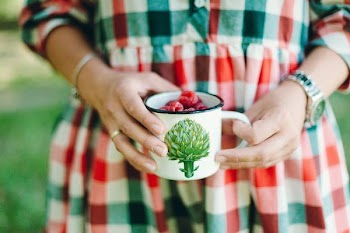 person holding cup of fruits