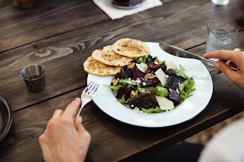 person holding cutlery in front of vegetable salad