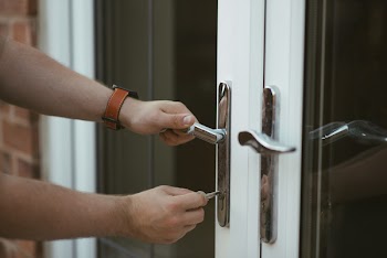 Person Holding Door Lever and Key