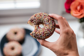 Person Holding Doughnut With Sprinkles