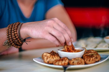 Person Holding Food and Dipping on Sauce