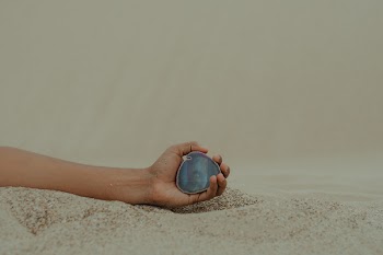 Person Holding Gemstone on Seashore