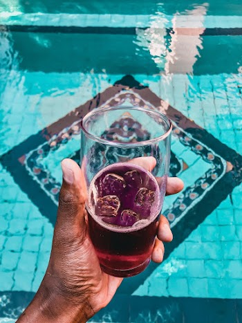 Person Holding Glass of Purple Beverage