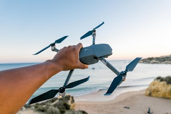 Person Holding Gray and Black Quadcopter Drone