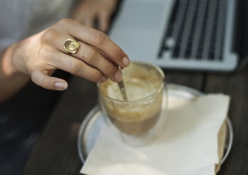 Person Holding Gray Stirrer on Clear Drinking Glass