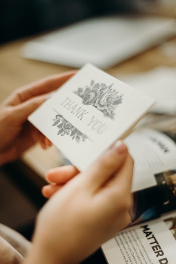 Person Holding Grey and Gold Card