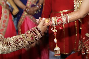 Person Holding Hands Wearing Red and Brown Dress