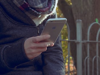 Person Holding Iphone at Park