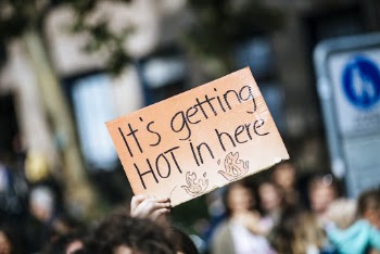 Person Holding It's Getting Hot in Here Sign