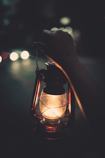 Person Holding Kerosene Lamp