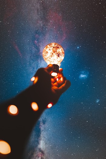 Person Holding Light Bulb With String Lights Inside