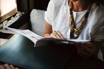 person holding magazine while sitting