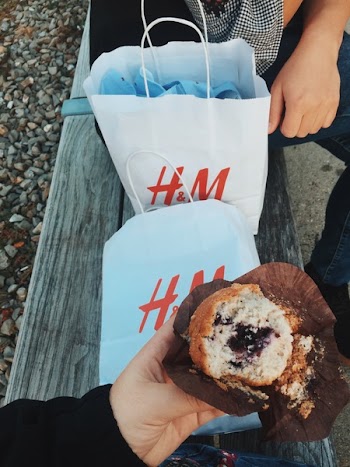 Person Holding Muffins Near the Two White H&amp;m's Paper Bags