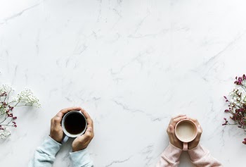 Person Holding Mug on Table