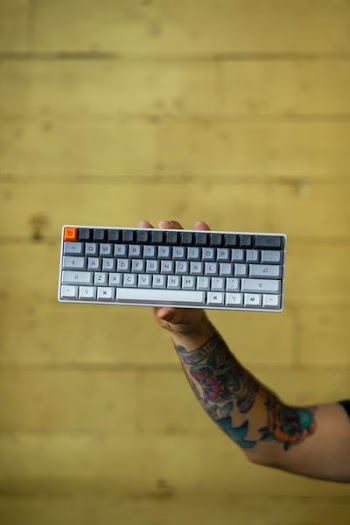 person holding multicolored wireless computer keyboard