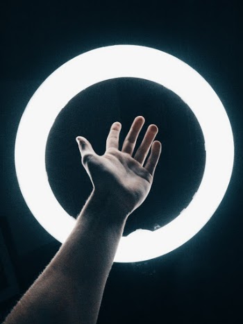 Person Holding Out Left Hand Onto Light