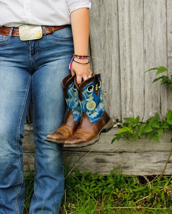 person holding pair of boots