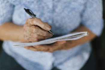 Person Holding Pen and Notebook