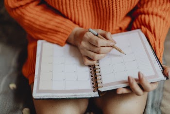 Person Holding Pen and Planner