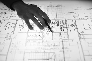 Person Holding Pen Point On Blueprint