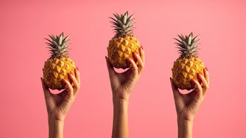 Person Holding Pineapples