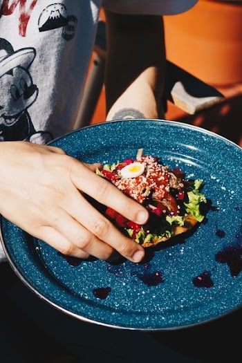 person holding pizza on plate