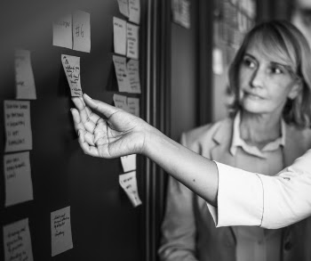 Person Holding Post-it on Board