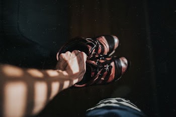 person holding red-and-black basketball shoes