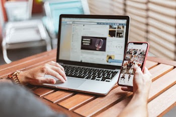 Person Holding Red Iphone X and Macbook Pro