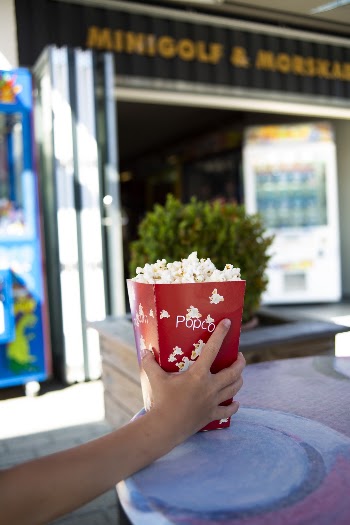 Person Holding Red Popcorn Box