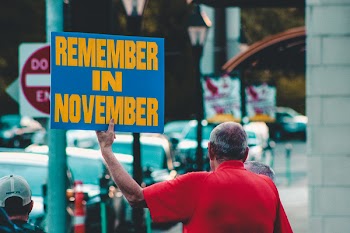 Person Holding Remember in November Sign