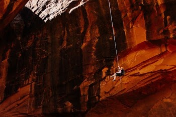 person holding rope in side cave