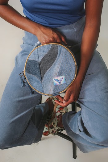 Person Holding Round Blue and Black Leather Case