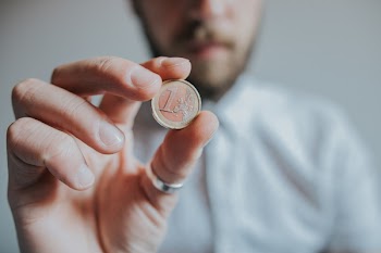 Person Holding Round Gold-colored Coin